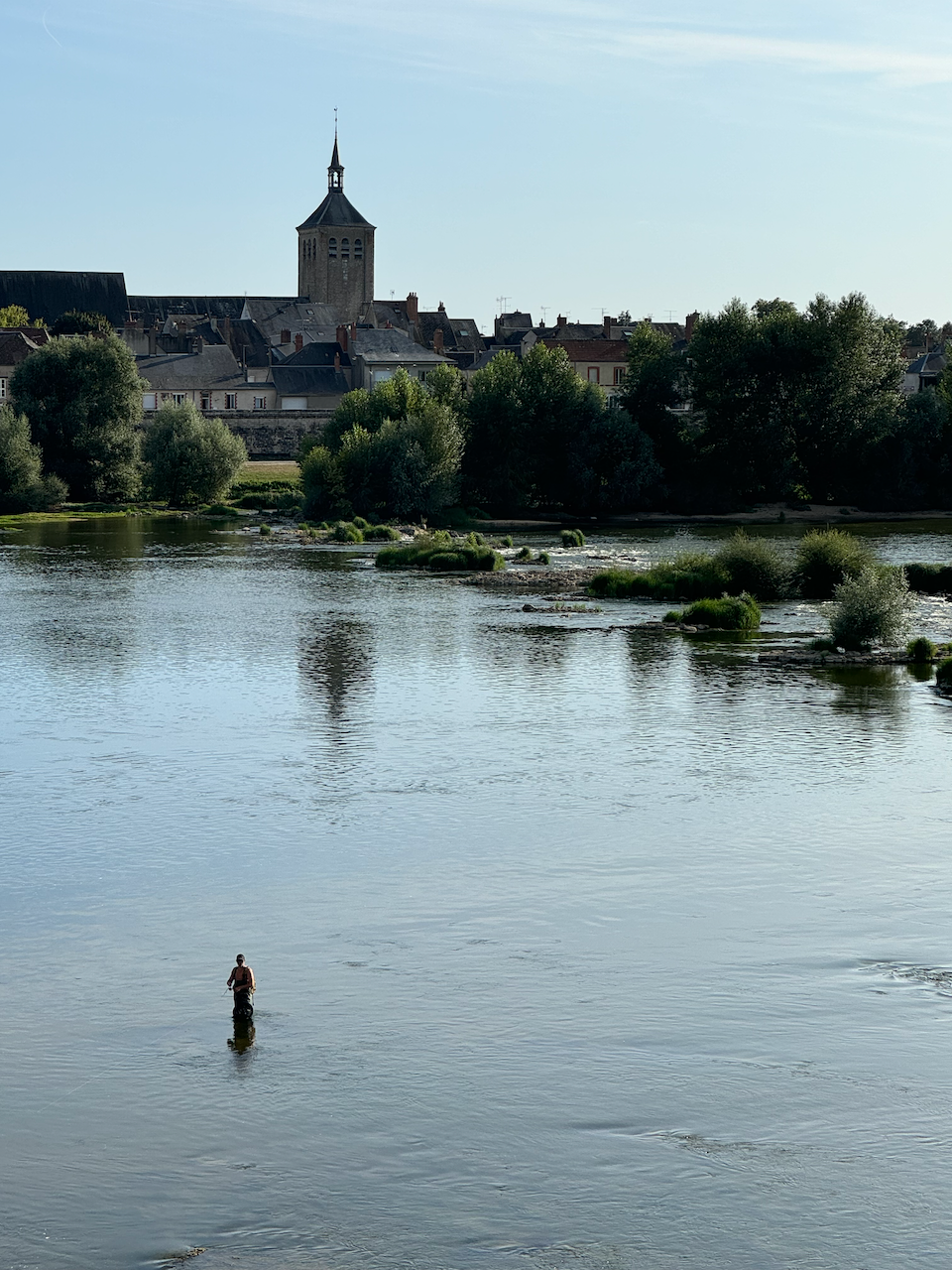 Sunset over Jargeau with a man fishing in the river